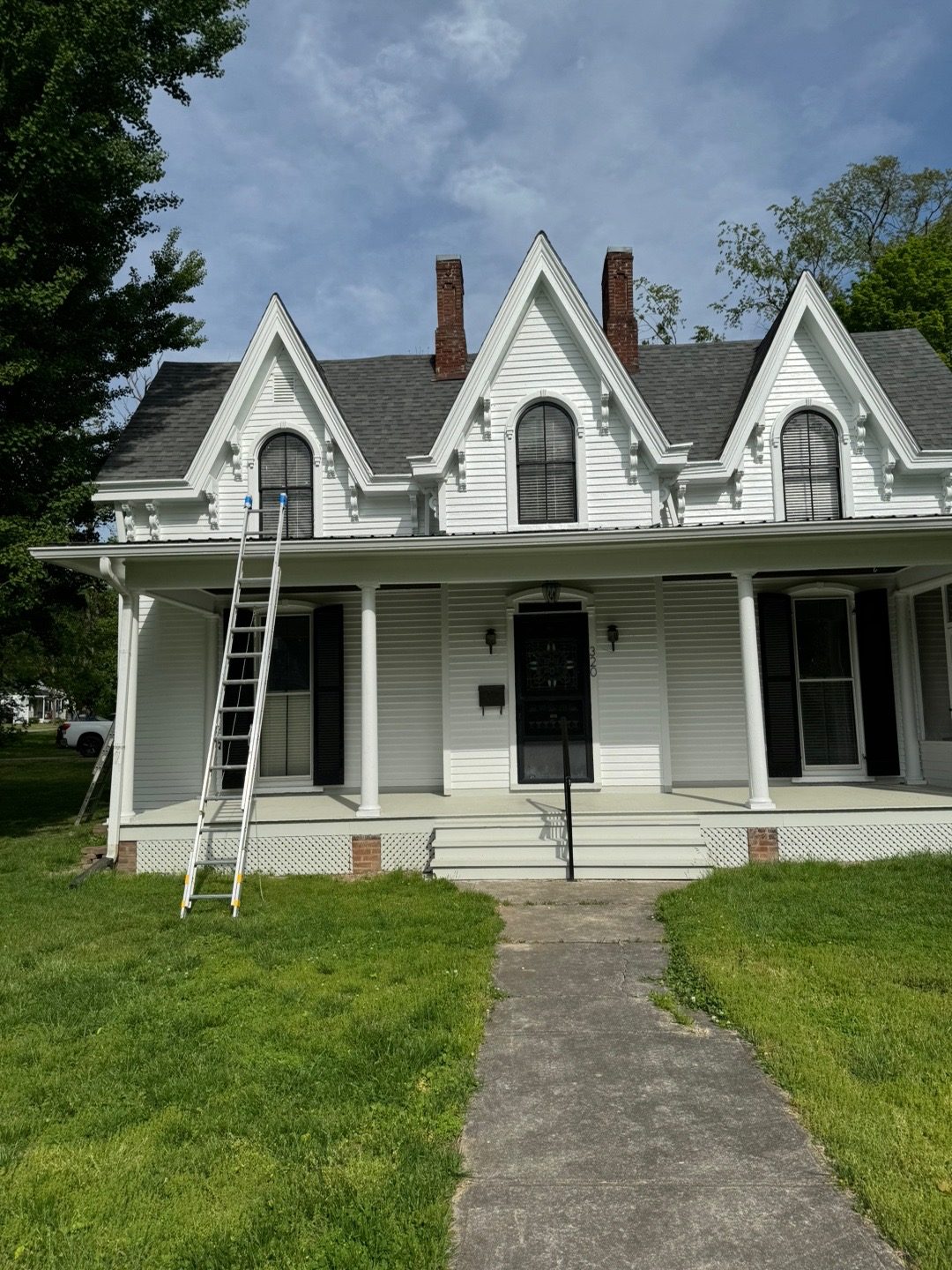 Historic white farmhouse exterior after professional repainting
