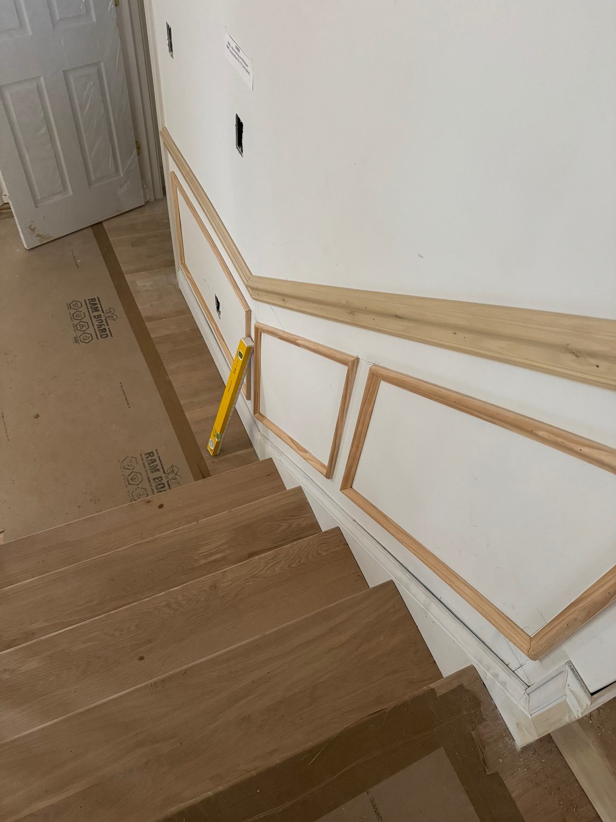 Staircase with new white wainscoting trim installed