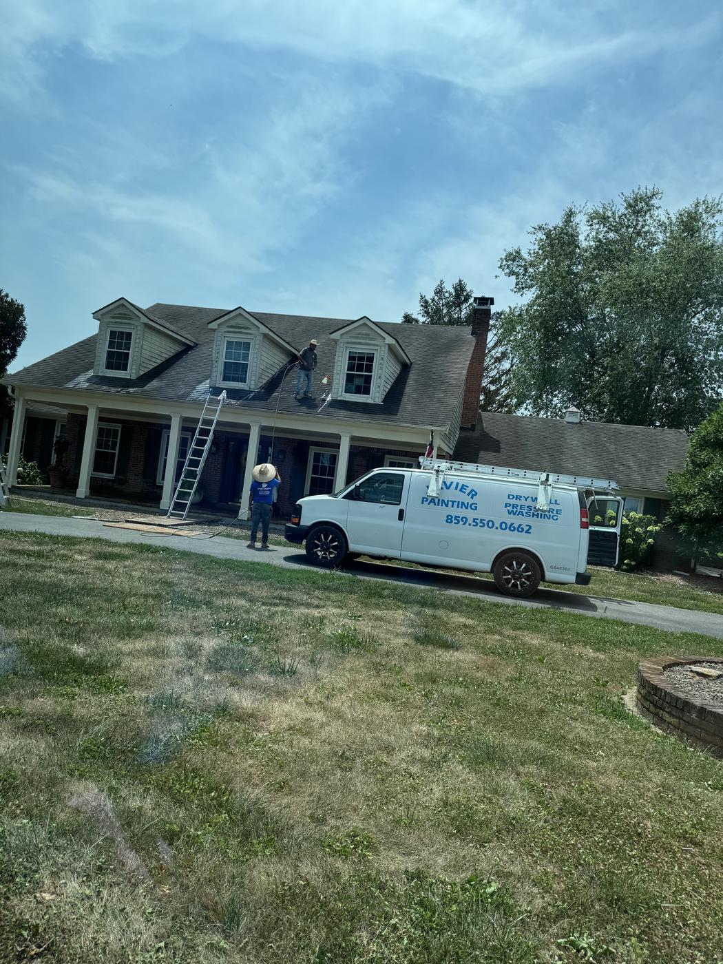 Javier Painting crew and lift equipment painting a home exterior