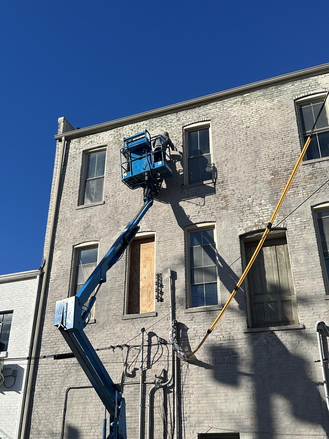 Lift equipment reaching the upper floors of a historic brick building