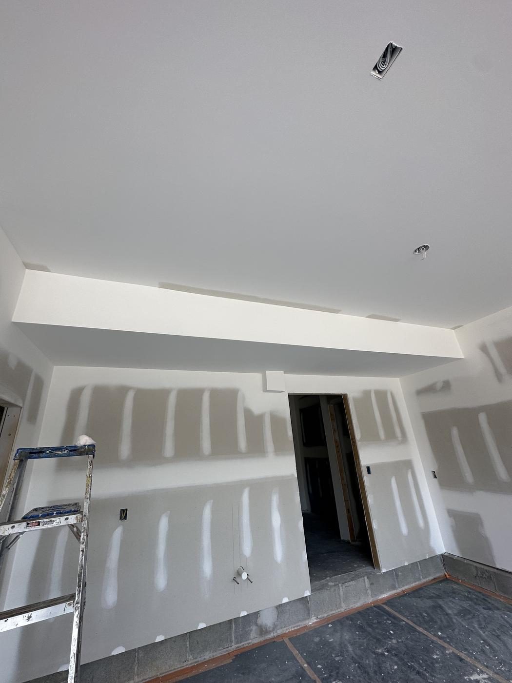 New construction room with drywall ceiling beam detail, ready for paint