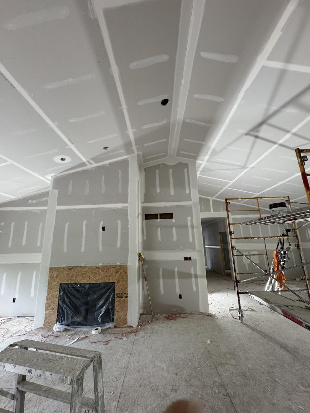 Living room with drywall repair in progress around the fireplace