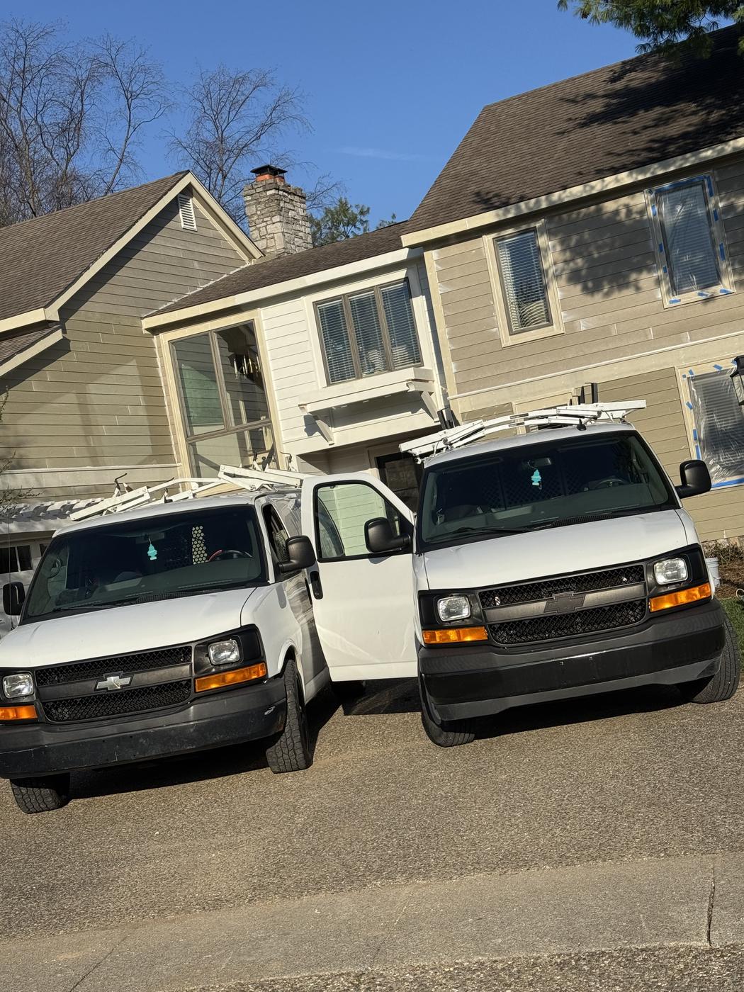 Two Javier Painting company vans parked and ready at a job site