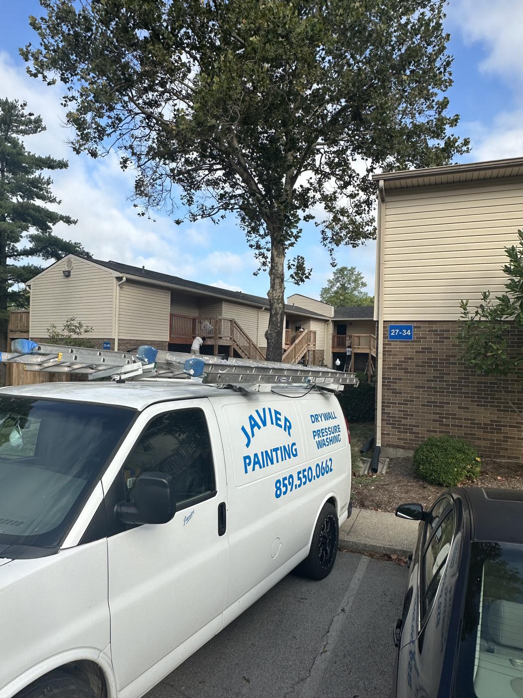 Javier Painting van parked at a townhome community job site