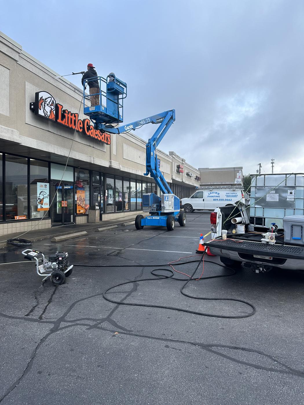 Lift equipment and company van set up at a commercial storefront
