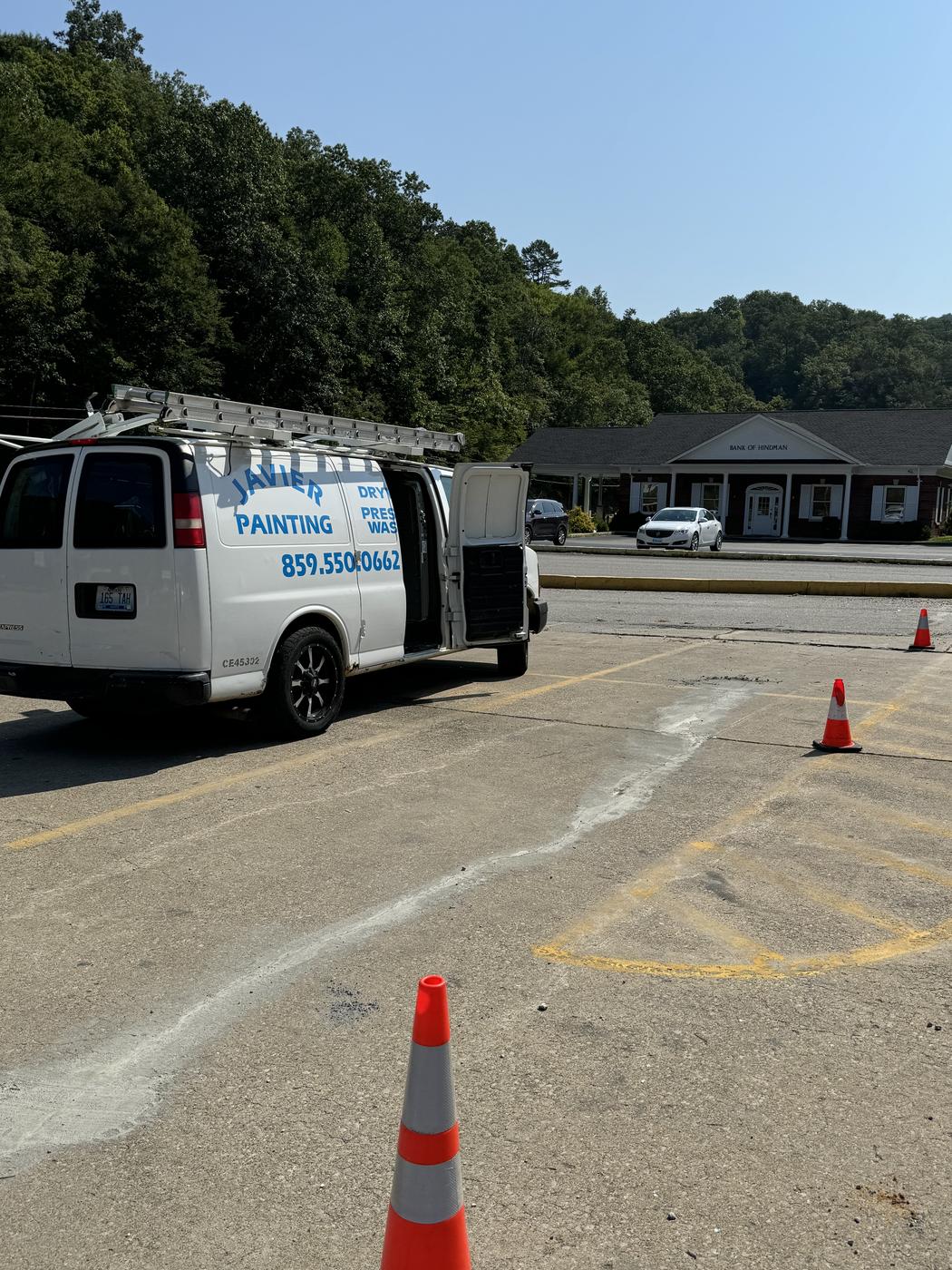 Company van and lift equipment staged with safety cones set