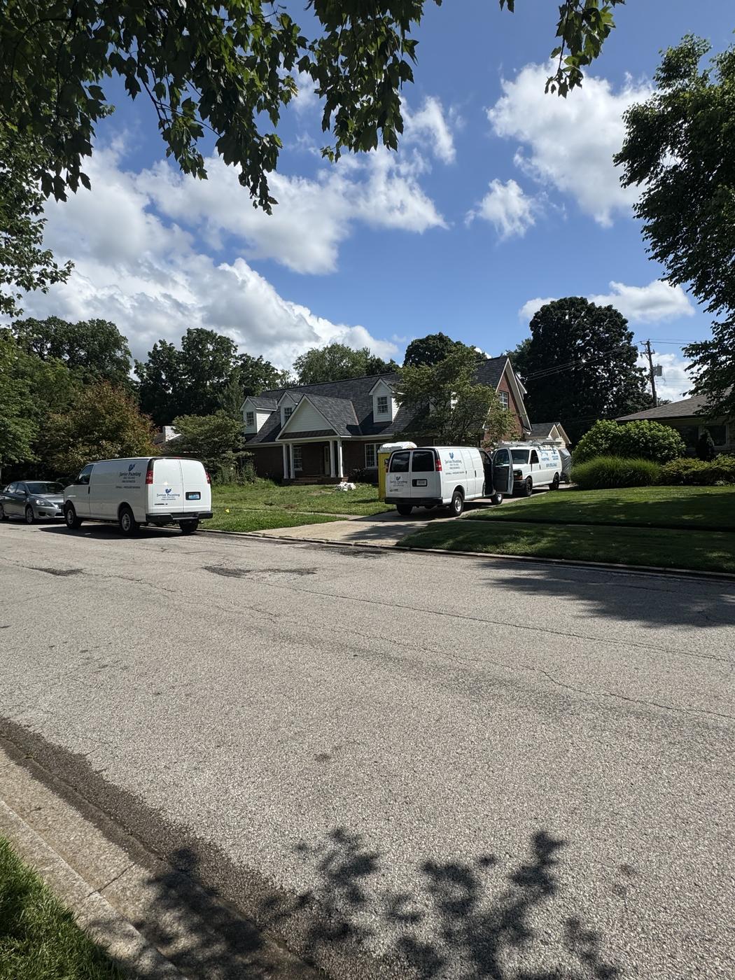 Multiple Javier Painting vans parked along a residential street