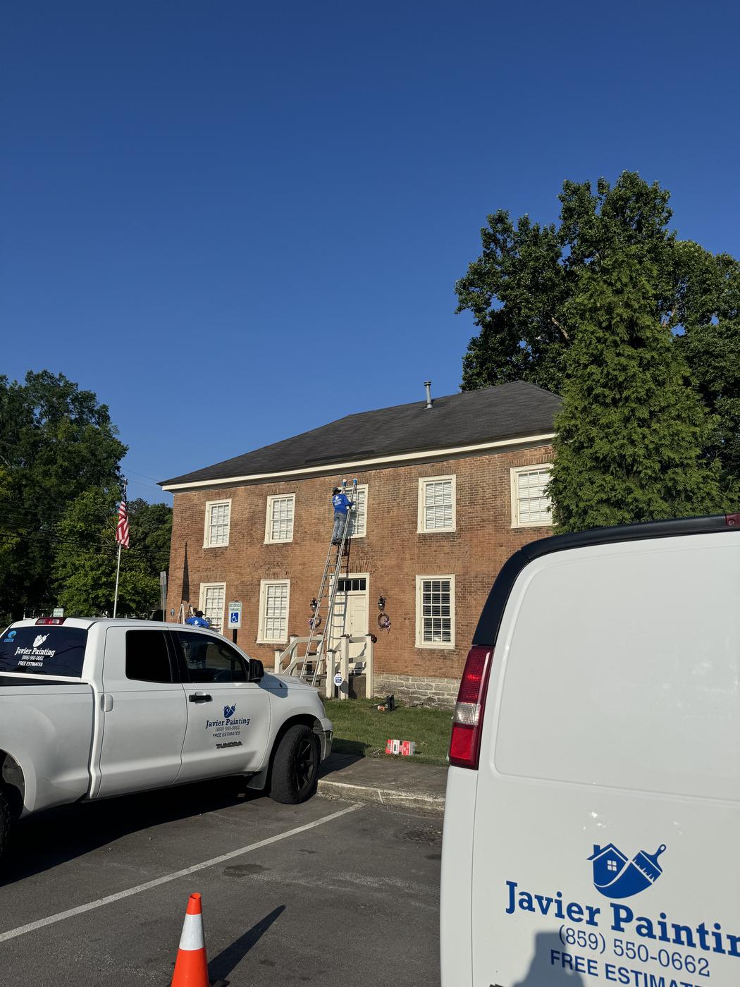 Company truck and van parked at a historic brick building