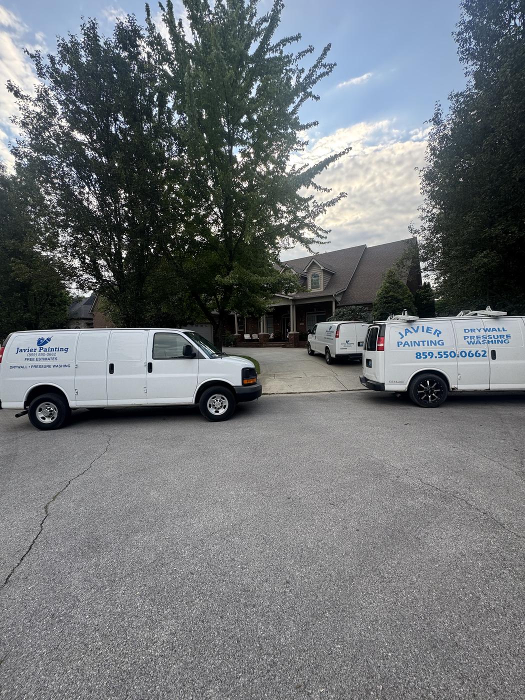 Two Javier Painting vans parked at a townhome job site