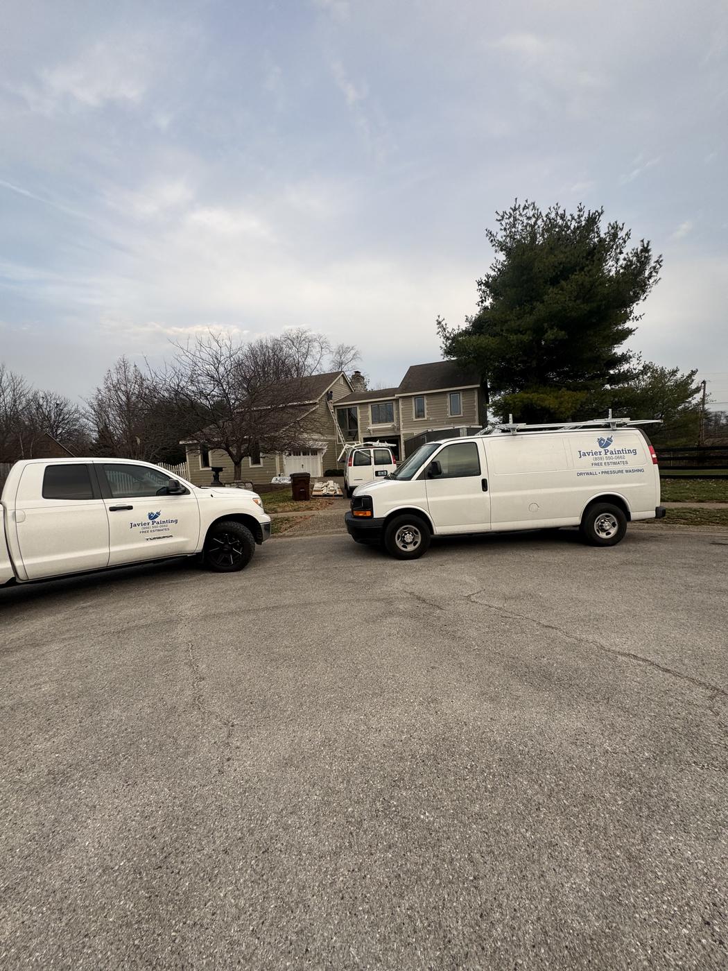 Javier Painting vans parked together in a residential neighborhood